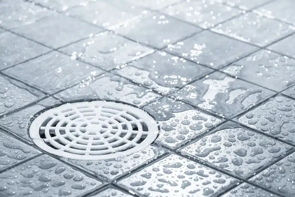 Water flowing into commercial bathroom drain in Sacramento, CA.